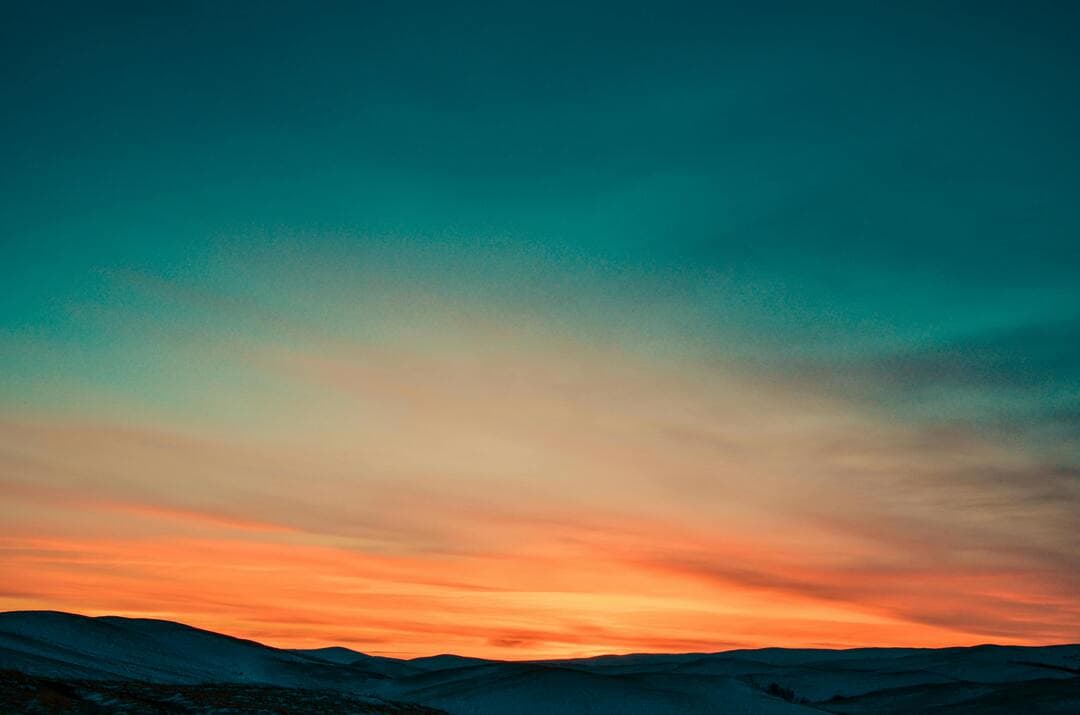 Sunset Over Snow Covered Mountains Image.
