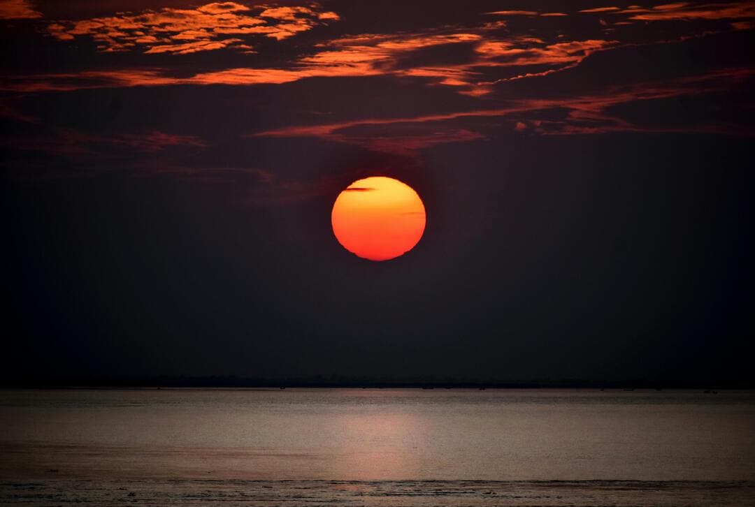 Sunset Over a Body of Water Image.