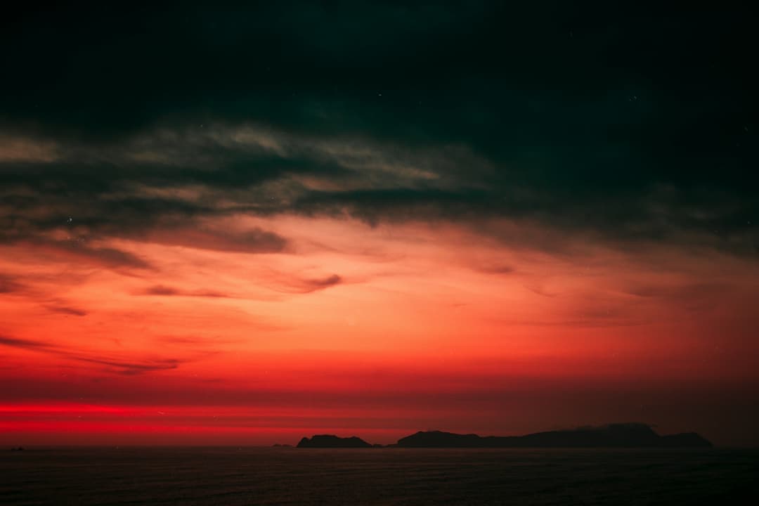 Red Dusk Over Calm Waters Image.